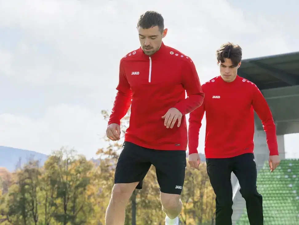 Fußballspieler im roten Trainingsanzug – Teamsport und Sportbekleidung bei Sport Duwe Nordenham im Landkreis Wesermarsch